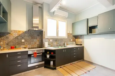 a kitchen with dark brown cabinets and a window at ATHENS Penthous at Center in Athens