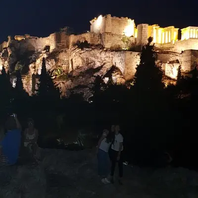 a group of people taking pictures of a castle at night at ATHENS Penthous at Center in Athens