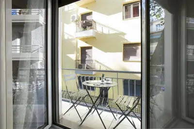 a balcony with a table and chairs and a window at Victoria Sq., A cozy and stylish apartment in Athens