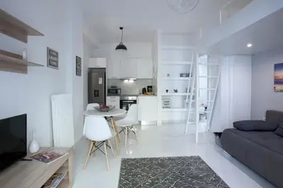a white living room with a couch and a table at Victoria Sq., A cozy and stylish apartment in Athens