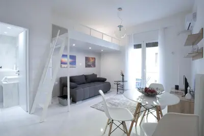 a white living room with a couch and a table at Victoria Sq., A cozy and stylish apartment in Athens