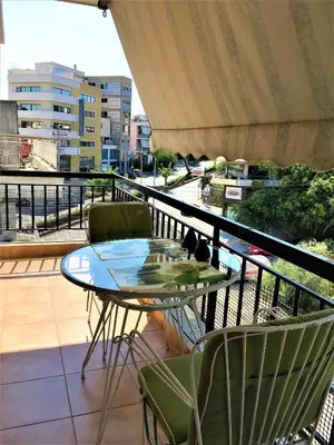 a balcony with a glass table and two chairs at Cozy Studio by seaside and tram in Athens