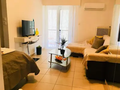 a living room with two beds and a television at Cozy Studio by seaside and tram in Athens