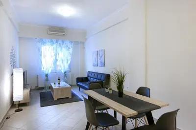 a living room with a table and chairs at Comfortable apartment at the foot of the Odeon of Herodes Atticus in Athens