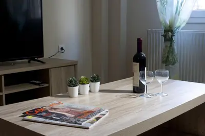 a bottle of wine and two glasses on a table at Comfortable apartment at the foot of the Odeon of Herodes Atticus in Athens