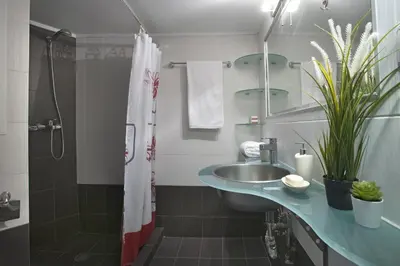 a bathroom with a sink and a shower at Comfortable apartment at the foot of the Odeon of Herodes Atticus in Athens