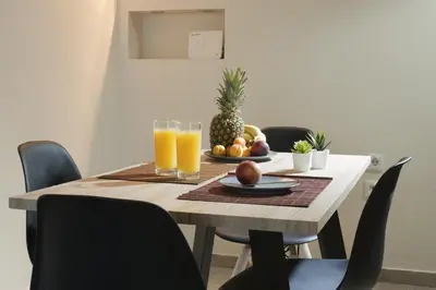 a table with a plate of fruit and glasses of orange juice at Comfortable apartment at the foot of the Odeon of Herodes Atticus in Athens