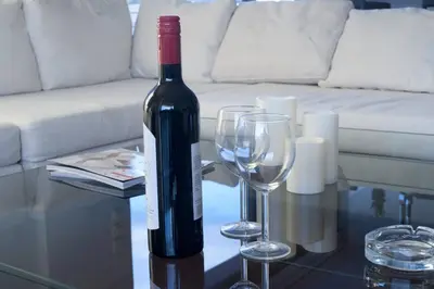 a bottle of wine and two wine glasses on a table at Voula, A modern, minimal and stylish, apartment in Athens