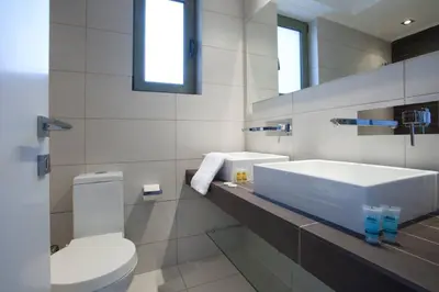 a white bathroom with a toilet and a sink at Voula, A modern, minimal and stylish, apartment in Athens