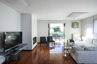 a living room with a white couch and a tv at Voula, A modern, minimal and stylish, apartment in Athens