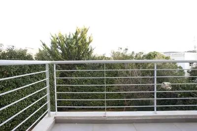 a metal fence with trees in the background at Voula, A modern, minimal and stylish, apartment in Athens