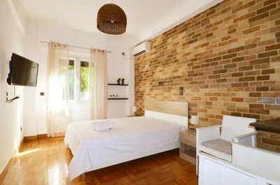 a bedroom with a brick wall and a bed at A modern rustic cosy apartment at the foot of Mount Lycabettus in Athens