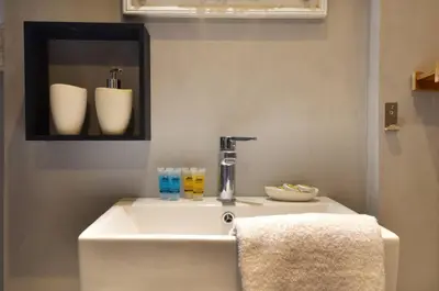 a white sink in a bathroom with a mirror at A modern rustic cosy apartment at the foot of Mount Lycabettus in Athens