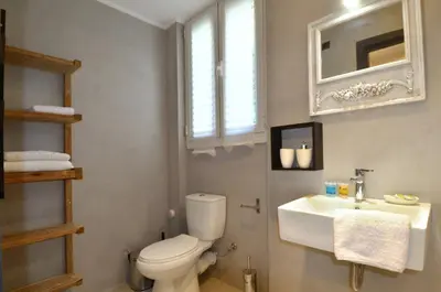 a bathroom with a white toilet and a sink at A modern rustic cosy apartment at the foot of Mount Lycabettus in Athens