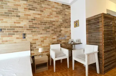 a bedroom with two chairs and a brick wall at A modern rustic cosy apartment at the foot of Mount Lycabettus in Athens