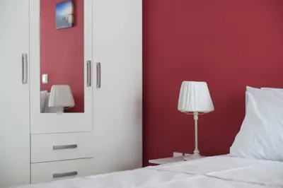 a bedroom with a white bed with a mirror and a lamp at Pop art apartment at Koukaki in Athens