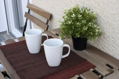 two white coffee mugs and a potted plant on a table at Pop art apartment at Koukaki in Athens