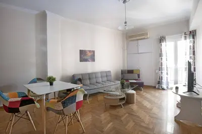 a living room with a couch and a table and chairs at Pop art apartment at Koukaki in Athens