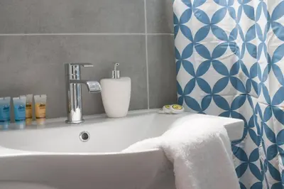 a bathroom with a white sink and a blue and white wall at Pop art apartment at Koukaki in Athens