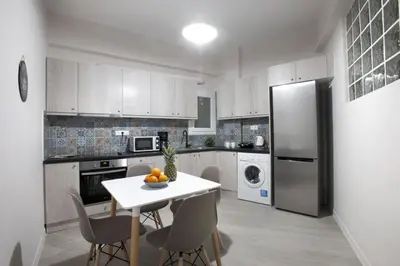 a kitchen with a white table and a refrigerator at Pop art apartment at Koukaki in Athens