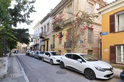 a row of white cars parked on a city street at Plaka, Apartment in the old historical neighborhood of Athens in Athens