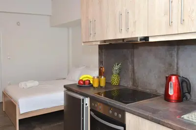 a small kitchen with a bed in a room at Koukaki, a minimal studio in Athens