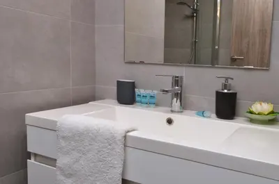 a bathroom with a white sink and a mirror at Koukaki, a minimal studio in Athens