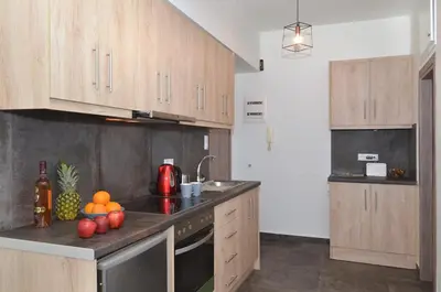 a kitchen with wooden cabinets and fruit on the counter at Koukaki, a minimal studio in Athens