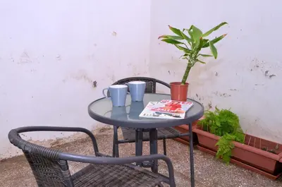 a small table with two cups and a potted plant at Koukaki, a minimal studio in Athens