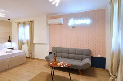a living room with a couch and a bed and a table at Petralona, a sweet and cozy apartment in Athens
