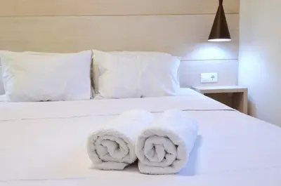 a white bed with towels on top of it at Petralona, a sweet and cozy apartment in Athens