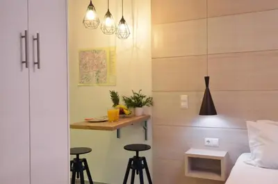 a bedroom with a bed and two bar stools at Petralona, a sweet and cozy apartment in Athens