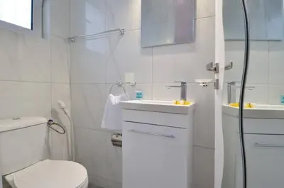 a white bathroom with a toilet and a sink at Agia Paraskevi, a cozy and minimal retire in Athens