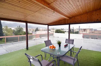 a table and chairs on the roof of a building at Agia Paraskevi, a cozy and minimal retire in Athens