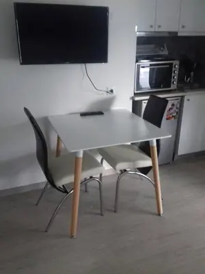 a white table with two chairs and a television on a wall at Agia Paraskevi, a cozy and minimal retire in Athens