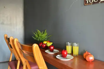 a wooden table with fruit on it with glasses of orange juice at Kerameikos, a lovely apartment in Athens