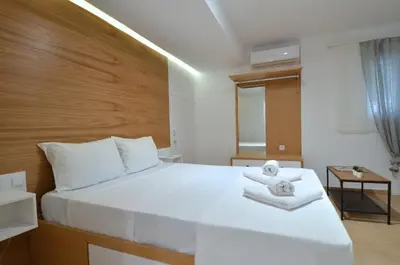 a bedroom with a large white bed with towels on it at Acropolis, a nice and minimal apartment in Athens