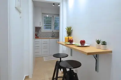 a kitchen with a counter and two stools in it at Acropolis, a nice and minimal apartment in Athens