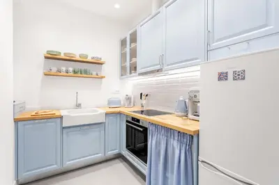 a kitchen with blue cabinets and a sink and a refrigerator at Chill Out In Retropolitan Hideaway at Alsos Park in Athens