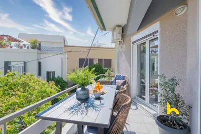 a balcony with a table and chairs on a patio at Sun-splashed sanctum with big balconies, Acropolis 2 in Athens