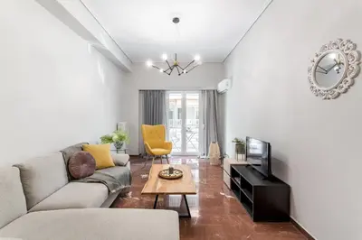 a living room with a couch and a tv at Explore History from a Chic Central Apartment in Athens