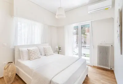 a white bedroom with a white bed and a window at Explore History from a Chic Central Apartment in Athens