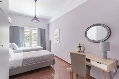 a bedroom with a bed and a desk and a mirror at Explore History from a Chic Central Apartment in Athens