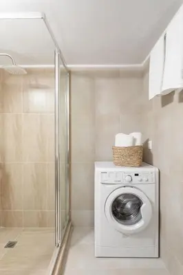 a washing machine in a bathroom with a shower at Explore History from a Chic Central Apartment in Athens