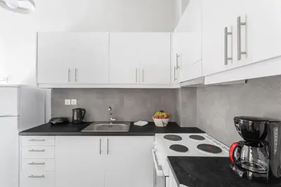 a white kitchen with a sink and a stove at Explore History from a Chic Central Apartment in Athens