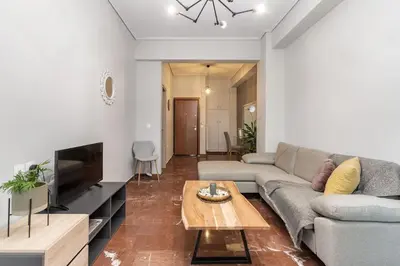 a living room with a couch and a table at Explore History from a Chic Central Apartment in Athens