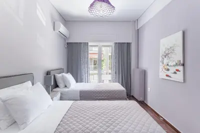 a hotel room with two beds and a window at Explore History from a Chic Central Apartment in Athens