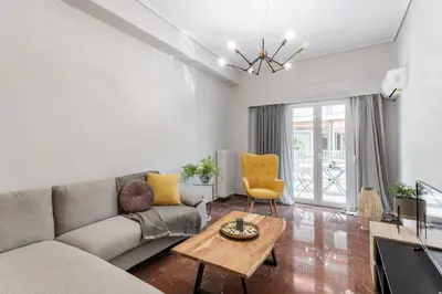 a living room with a couch and a table at Explore History from a Chic Central Apartment in Athens