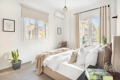 a white bedroom with a bed and a window at Stylish, 3-brdm Family Apartment near Acropolis! in Athens