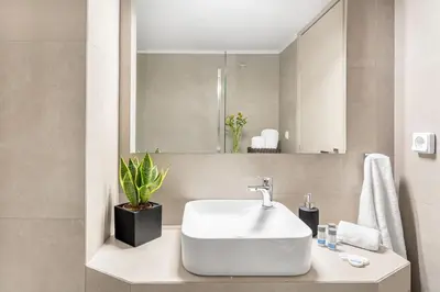 a bathroom with a white sink and a mirror at Stylish, 3-brdm Family Apartment near Acropolis! in Athens